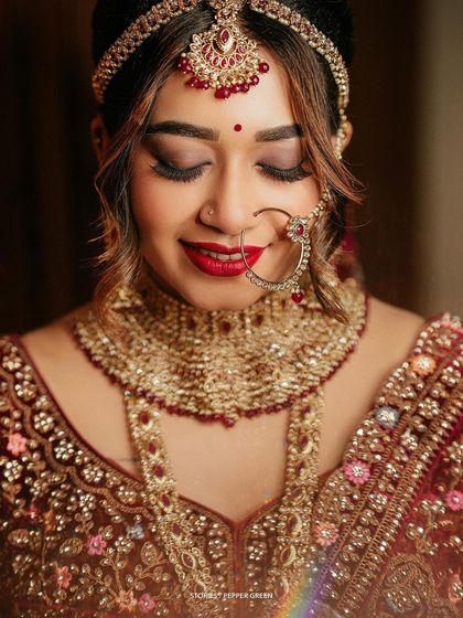 A serene portrait of the bride, Reshma, adorned in her magnificent North Indian bridal attire. The rich colors and intricate jewelry are captured in beautiful detail.
