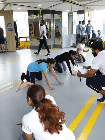 Our coaches are deeply involved in every community event. Here, a trainer gets ready to time participants at the start of the Plank Challenge, ensuring a fair and fun competition for everyone.
