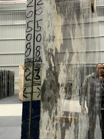 Here is another look at the marble selection process. I am inspecting the patterns and quality of a large onyx slab in a warehouse. This careful attention to detail ensures a flawless and luxurious finish for my client's home.