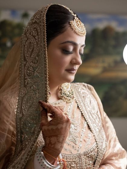 A close-up portrait of Sachi. The soft lighting highlights the flawless finish of her skin and the intricate details of her jewelry.