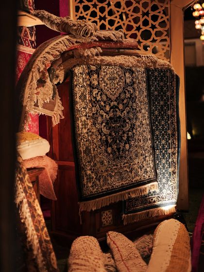 A beautifully intricate carpet, spotlit to highlight its craftsmanship. Textiles are one of my favorite elements to work with, and they played a huge role in bringing this theme to life.