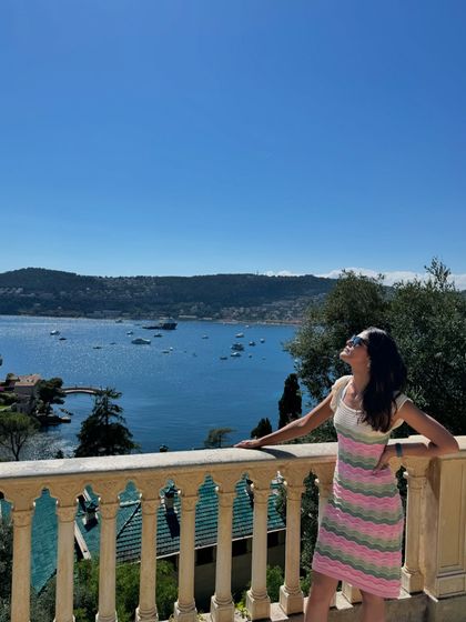 Enjoying the panoramic sea views from a balcony in France. The striped pattern of my dress echoes the gentle waves of the Mediterranean.