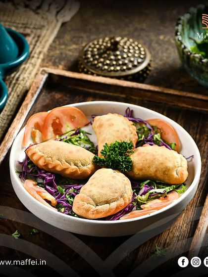 Sambousek Lahme are savory pastries filled with spiced minced lamb. Each one is a small parcel of flavor, perfect for starting your meal.