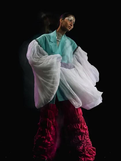 A long-exposure shot from the "Metaverse" editorial, capturing the movement of the voluminous sleeves and the futuristic makeup.