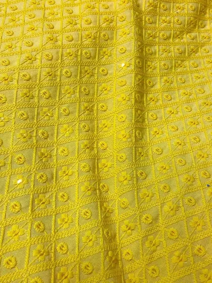 A vibrant yellow Chikankari fabric, ideal for a Haldi ceremony kurta or a bright festive outfit. The detailed threadwork creates a rich texture.