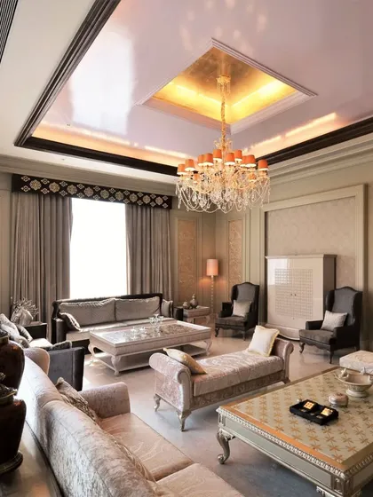 A classic living room boasting intricate wall panels and luxurious fabrics. The space is designed to be both grand and comfortable, perfect for formal entertaining and quiet relaxation.