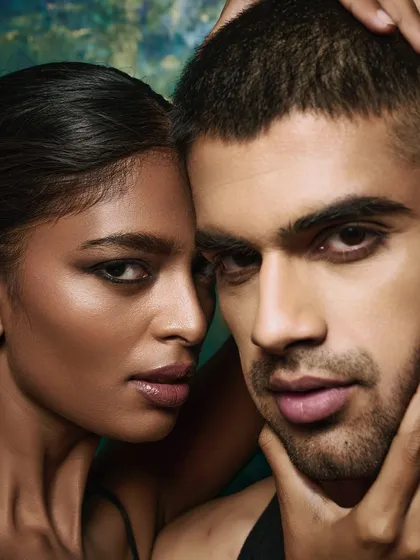 A tender moment captured between the two models. The framing is tight, focusing entirely on their faces and the subtle interaction between them.