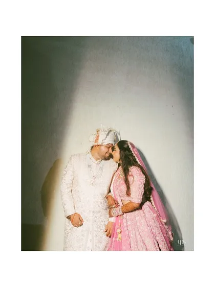 An artistic portrait of Ayush and Sakshi in their traditional wedding attire. The dramatic slash of light creates a high-contrast, intimate moment that feels both modern and timeless.