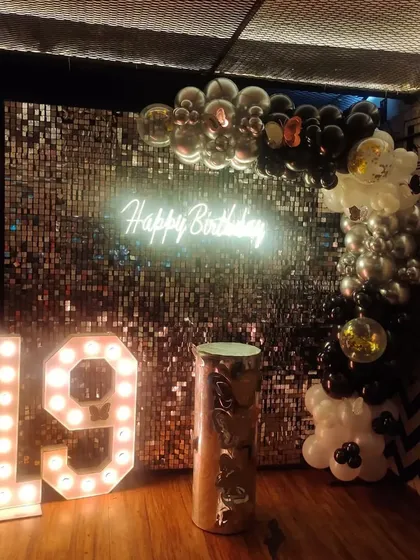 A black and silver sequin backdrop for a 19th birthday, creating a cool and edgy vibe.