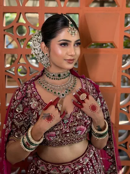 A close-up showing the details of the bride's makeup and the beautiful emerald jewellery.