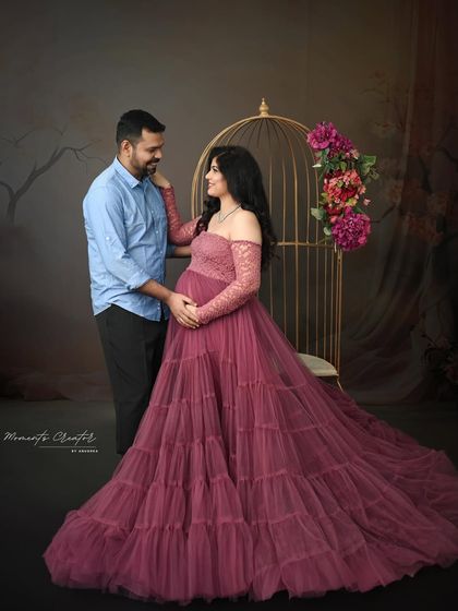 A fairytale moment for the expecting couple. The mom-to-be looks radiant in a mauve gown next to my golden birdcage prop, creating a whimsical and romantic scene.