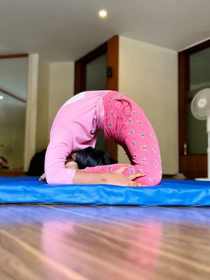 This student holds a beautiful scorpion pose on the mat, showcasing her amazing back flexibility and control. This is an advanced skill we build up to over time.