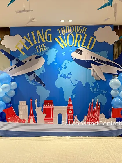 'Flying Through the World' was the theme for this adventurous first birthday. The backdrop features a world map, airplanes, and famous landmarks.