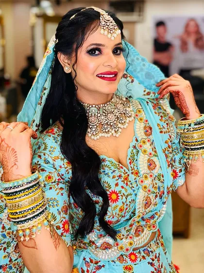 A happy client showing off her party look. The combination of her bright outfit, intricate jewelry, and perfectly applied makeup creates a joyful and festive appearance.