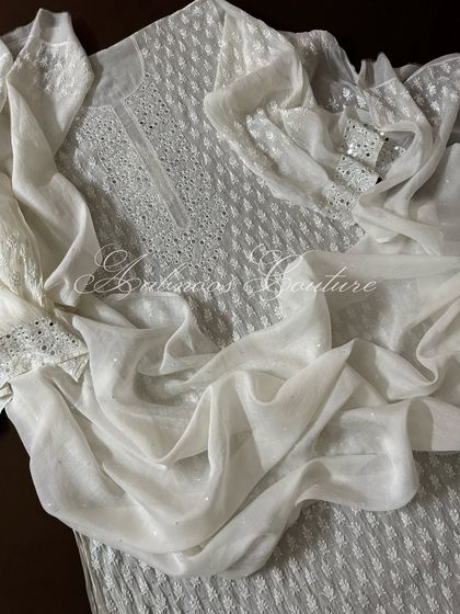 Another draped view of the suit, emphasizing the lightness of the fabric despite the heavy embellishments.