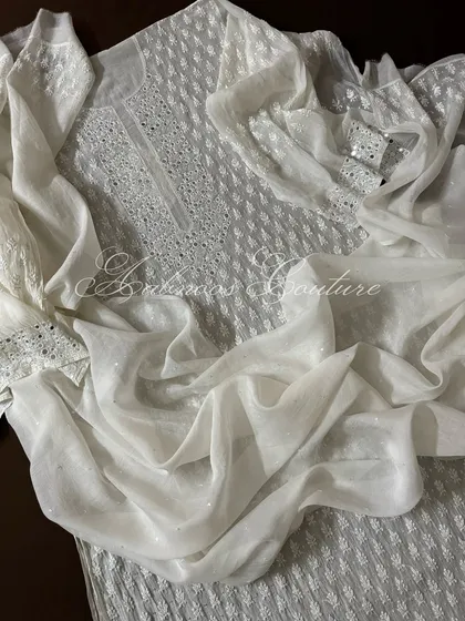 Another draped view of the suit, emphasizing the lightness of the fabric despite the heavy embellishments.