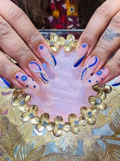 A trendy and protective evil eye design, using a bold blue on a sheer pink base with glitter accents.