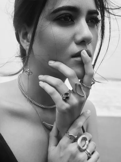 A pensive black and white close-up. The makeup details, like the defined brows and lips, stand out beautifully.