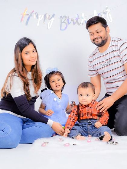 The whole family together for a first birthday studio photoshoot. I guide everyone into comfortable poses to get natural-looking group photos.