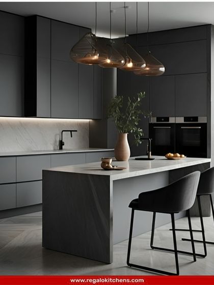 This minimalist island kitchen in matte grey is the definition of understated elegance. The simple, clean lines of the cabinetry and the solid island are perfect for a clutter-free lifestyle, with two bar stools indicating a space for casual conversation.