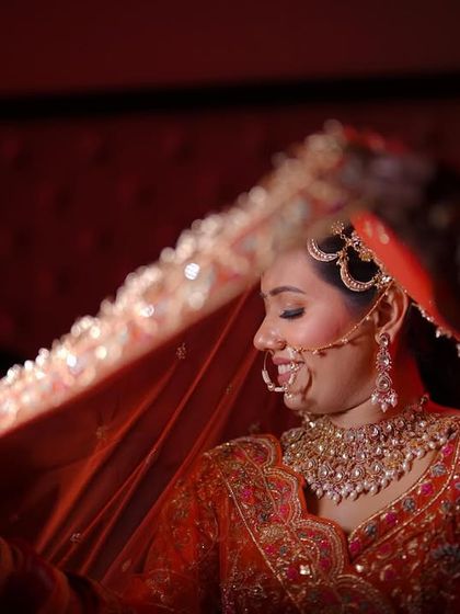 A playful and shy moment captured under the veil. The warm lighting adds a beautiful glow to this candid bridal shot.