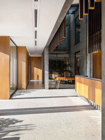 The main circulation corridor at the Laxcon office is defined by clean lines, natural light, and a simple palette of terrazzo, concrete, and wood, creating a calm and efficient pathway.
