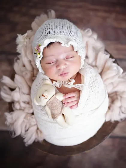 A sleeping newborn, swaddled in white and holding a tiny teddy bear. These are the sweet details I love to capture.