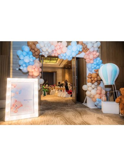 The entrance to "Parv's Beary Land." A marquee welcome sign and a large balloon arch in pastel blue, pink, and brown set a warm and inviting tone for the celebration.
