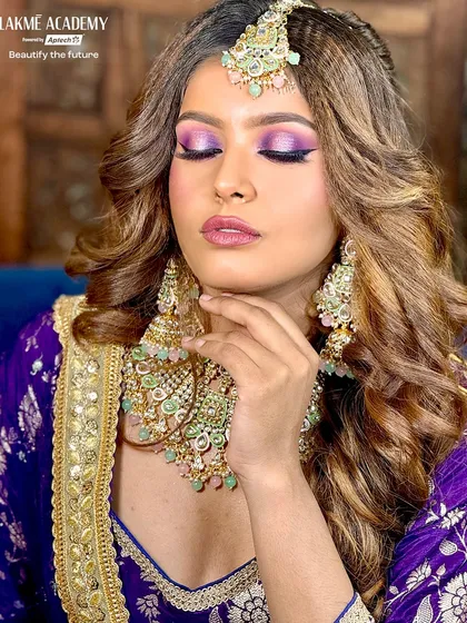 A soft, glamorous pose showing the full effect of the purple-themed engagement makeup. Our portfolio-building sessions teach students how to direct models to capture the best angles of their work.