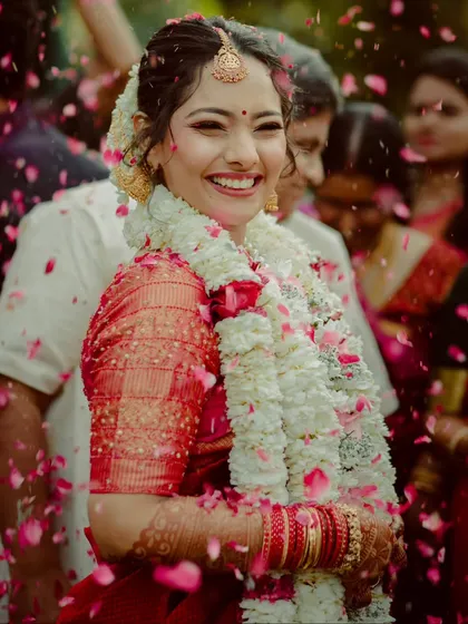 The pure joy of a South Indian bride, showered with petals after her wedding ceremony. Her radiant smile and the vibrant traditions make for beautiful, timeless photographs.