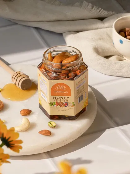 A product shot for a jar of honey with nuts. I used a clean, tiled background, a honey dipper, and scattered nuts to highlight the natural ingredients and create a bright, wholesome image.