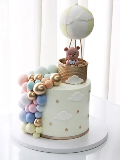 Sweet beginnings! This baby shower cake features a hot air balloon theme with a soft pastel balloon cascade, perfect for celebrating the upcoming arrival.