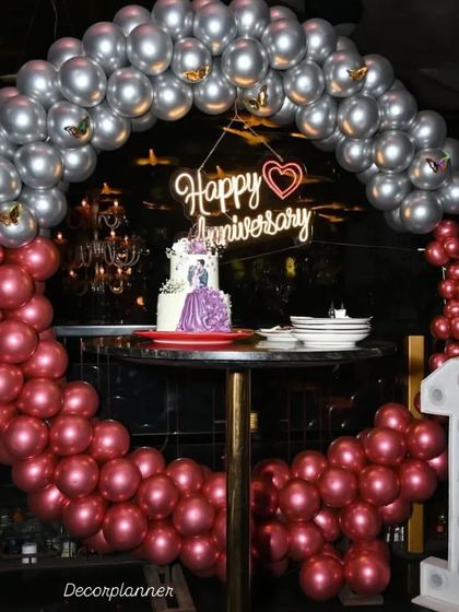 The celebration in full swing. The circular balloon arch perfectly frames the anniversary cake, making the cake-cutting moment even more special and picturesque.