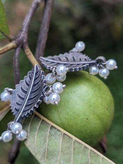These cute leaf-shaped ear studs with pearls are made with a black polish silver replica finish. They have a beautiful, natural elegance.