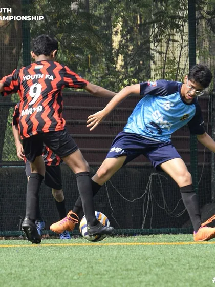 Two players locked in a duel for the ball during the Youth Championship. The focus and determination are clear to see.