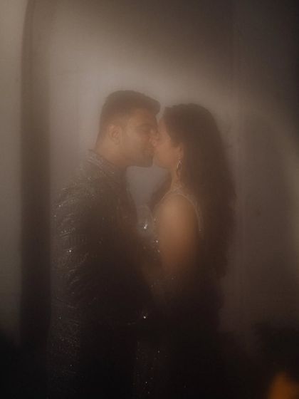 An artistic, blurry shot of the couple sharing a kiss, creating a sense of a stolen, private moment.