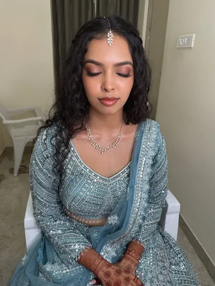 Sushmita with her eyes closed, showing the soft and blended eyeshadow. The look is glamorous yet understated, perfect for a sophisticated reception.