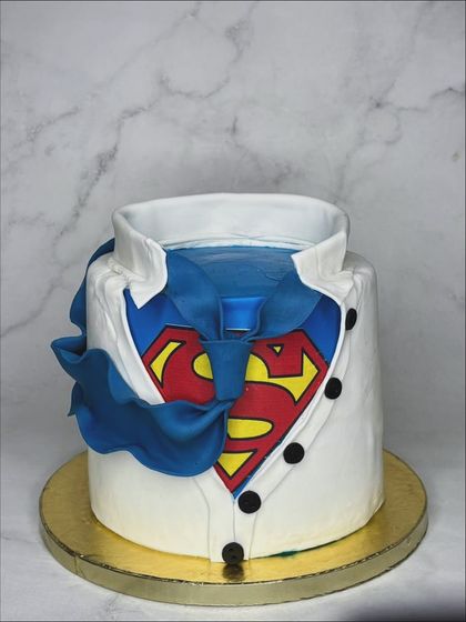 The second of two cakes for the same birthday dad. This one shows Clark Kent's shirt ripping open to reveal the Superman suit underneath. It's a fun and creative take on the superhero theme.