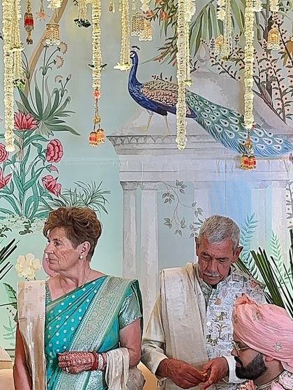 Another moment from the Pichwai-themed ceremony, capturing the emotions of the family against the backdrop of traditional art and hanging flowers.