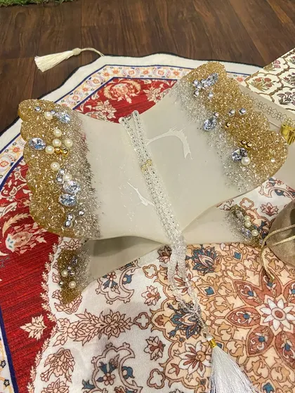 A beautiful Ramadan gift set featuring a dome-shaped prayer mat with an intricate red and white design. The set includes a custom Quran holder and a crystal tasbeeh, making it a perfect gift for the holy month.