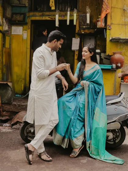 A romantic pose with a vintage scooter in a rustic Mumbai lane, blending traditional outfits with a touch of urban nostalgia.