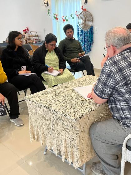 Mentor Lawrence Fray providing direct feedback to a small group of writers. This personalized attention is a cornerstone of our teaching philosophy, ensuring you get the guidance you need.