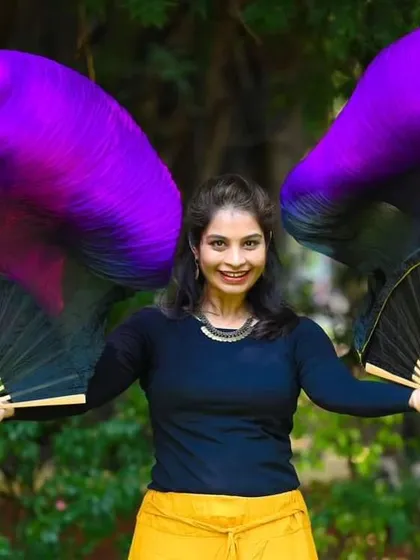 My fabric and silk fan performances are perfect for daytime events or when you want a softer, more elegant atmosphere. Here, I'm holding a pair of vibrant silk veil fans, which I use to create floating, graceful movements that feel like painting on air.