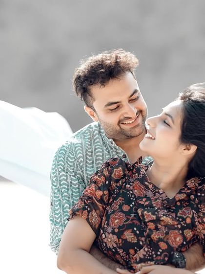 A joyful and candid close-up, with a light blue cloth flowing in the wind. The genuine smiles and laughter make this a heartwarming shot.