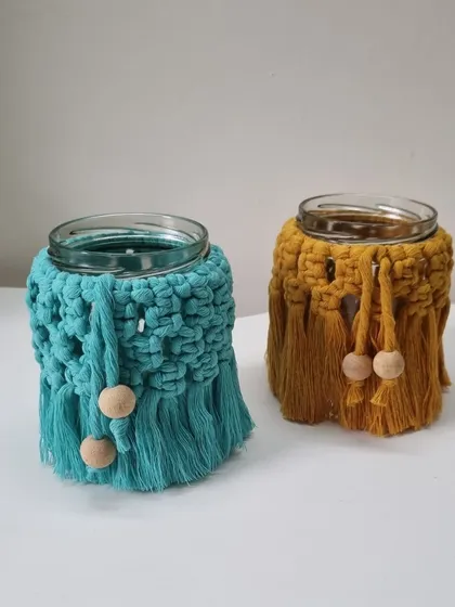 A pair of my macrame jar covers in teal and mustard, showing how they can be displayed together.
