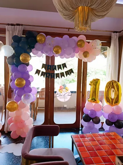 A balloon arch decoration in a restaurant for a 10th birthday party.