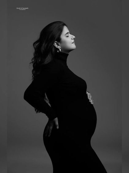 A black and white version of a serene moment. This edit adds a timeless, classic feel to the portrait, emphasizing the beautiful shape and the quiet emotion of pregnancy.