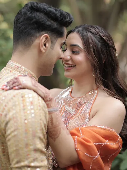 A happy and intimate moment from a God Dhana ceremony. Her makeup is soft and radiant, with warm tones that enhance her natural beauty and complement her orange outfit.