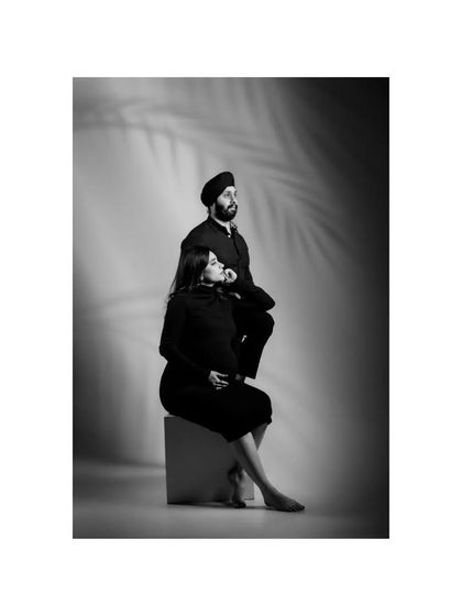 Awaiting a new life, this couple poses for a classic black and white maternity portrait. The dramatic lighting and their pensive expressions create a powerful and artistic image about the journey to parenthood.