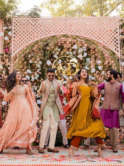 The entire family enjoying a fun, energetic dance performance at a beautiful outdoor mehendi.